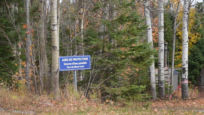 Une affiche inscrit «Aire de protection, source d'eau potable, Parc du Mont-Comi».