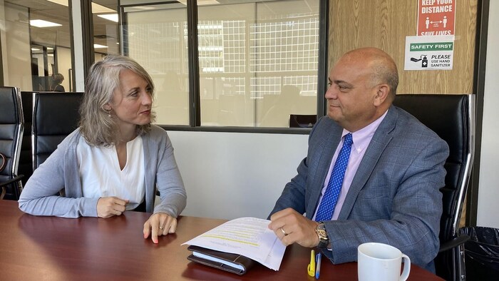 Une femme et un homme (Mélanie Gallant, directrice des communications, et José Samaniego, directeur pour les Amériques du Haut Commissariat des Nations unies pour les réfugiés (HCR) discutent dans une salle de réunion.