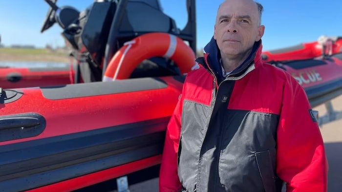 Un homme devant un bateau de sauvetage.