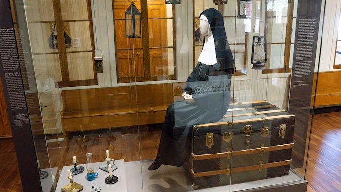 Un mannequin représentant une religieuse assise.
