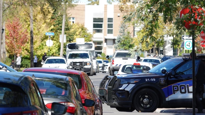 Des véhicules de police stationnés dans la rue.