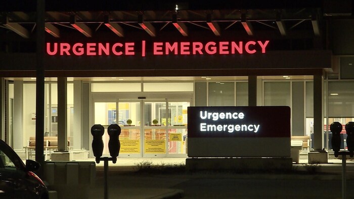 La façade de l'hôpital et de son urgence la nuit.