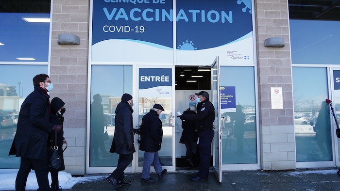 Des gens entrent dans un centre de vaccination.