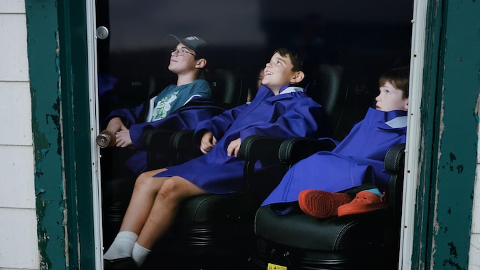 Des enfants envoûtés qui sont sur des sièges interactifs