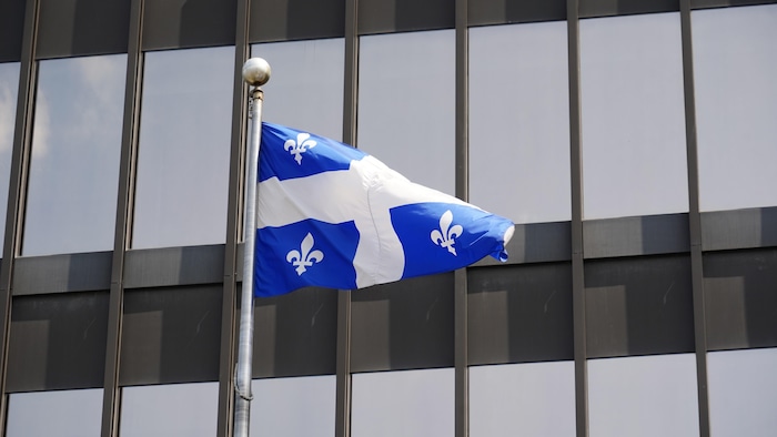 Un drapeau du Québec bat au vent devant le Palais de justice de Montréal.
