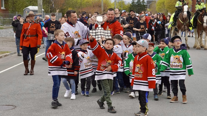 Des enfants marchent dans la rue pour le défilé.