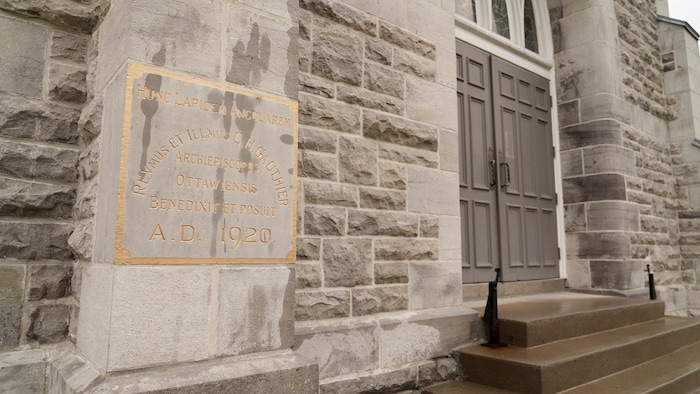 Une entrée d'église avec une inscription dessus.