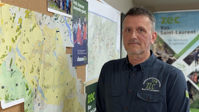 Portrait de Peter Camden à côté d'une carte topographique.