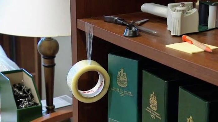 Un ruban adhésif pend de la tablette d'une étagère dans le bureau de député de Peter Julian.