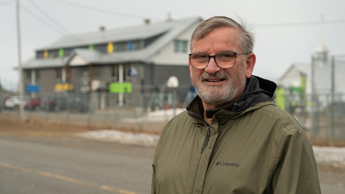 Portrait du maire devant la petite école de son village.