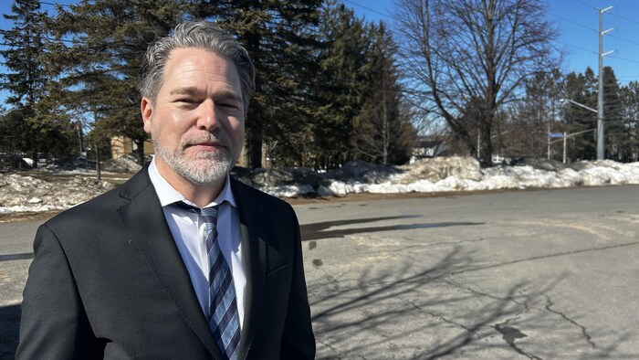 Jean-Philippe Raîche debout dans un stationnement. 