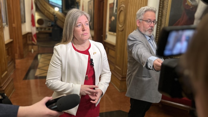 Une femme répond aux questions des journalistes.