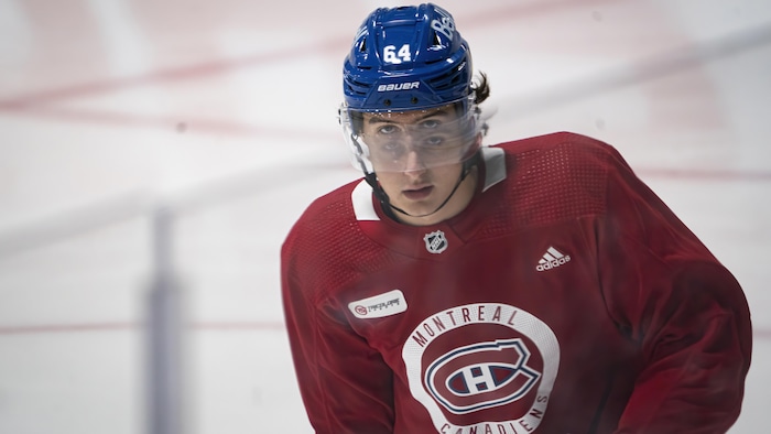 Un joueur de hockey se laisse glisser sur la patinoire.