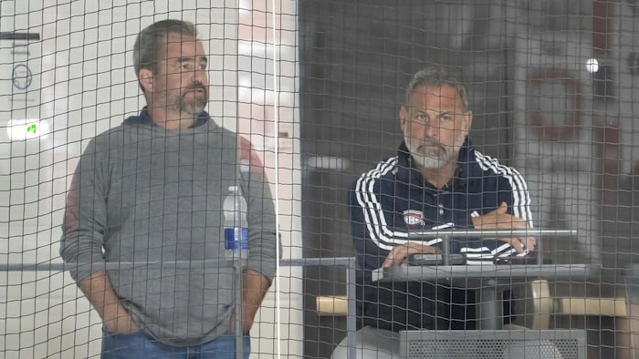 Deux hommes observent l'action de la passerelle, lors d'un entraînement.