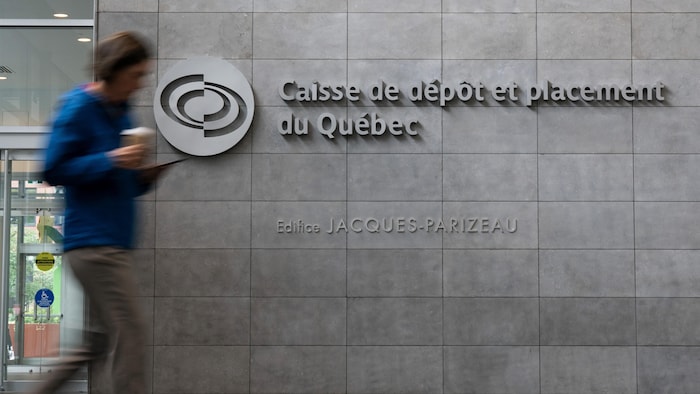 رجل يمر من أمام مكاتب صندوق الودائع والاستثمارات الكيبيكي (CDPQ) في مونتريال.