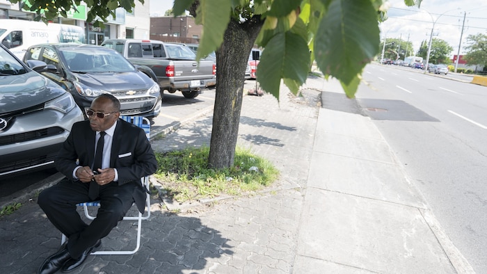 Sur une chaise, sous un arbre.