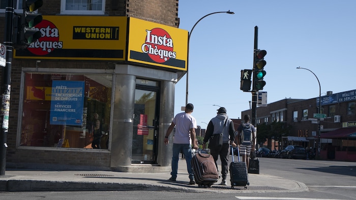 Deux hommes marchent avec leurs valises.