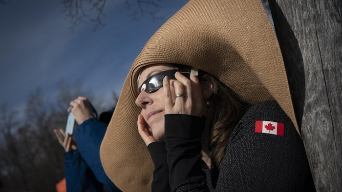 Une personne observe l'éclipse avec ses lunettes de protection au parc Jean-Drapeau de Montréal.