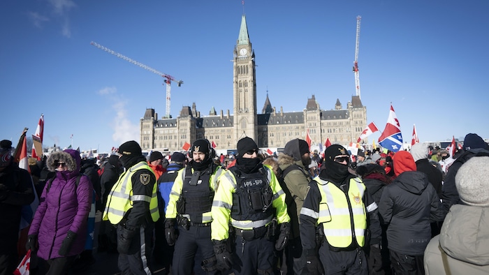 Des agents entourés de manifestants bien emmaillotés.