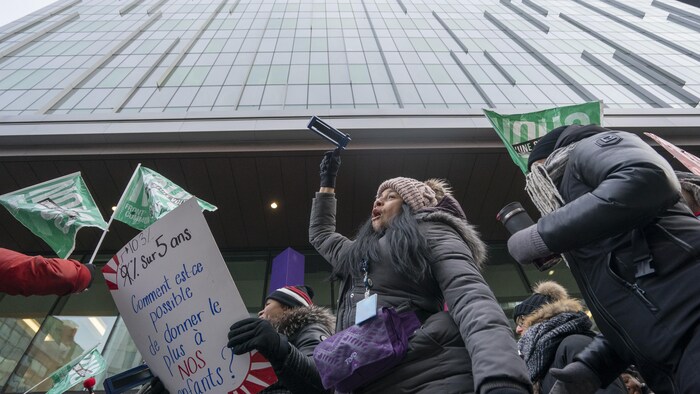 Des manifestants avec des pancartes devant un hôpital.