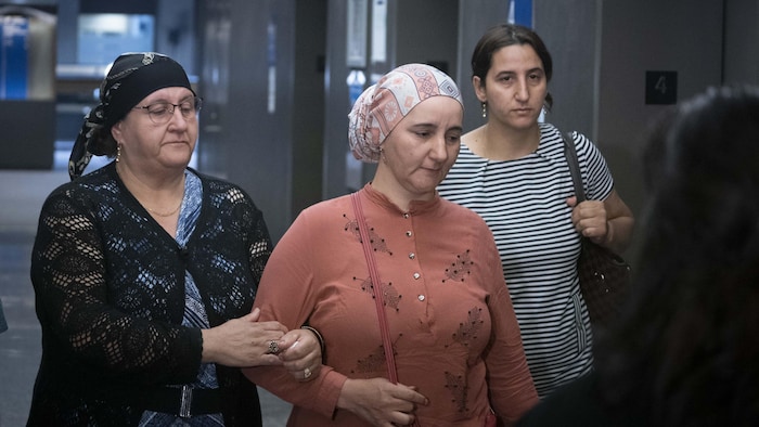 Deux femmes marchent dans les corridors du palais de justice.