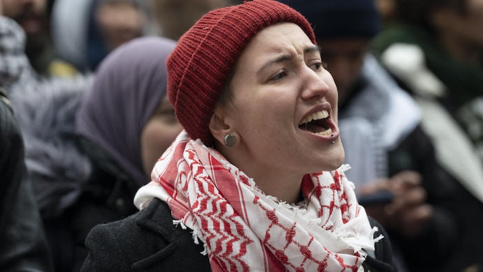A protester wearing a red and white Palestinian keffiyeh around his neck.