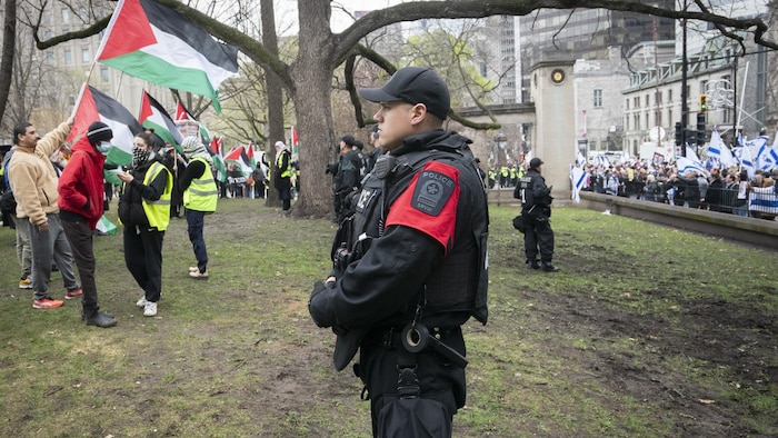 عناصر من شرطة مونتريال يفصلون بين متظاهرين داعمين للفلسطينيين في حرم جامعة ماكغيل ومتظاهرين مؤيدين لإسرائيل خارج حرم الجامعة في 2 أيار (مايو) 2024.