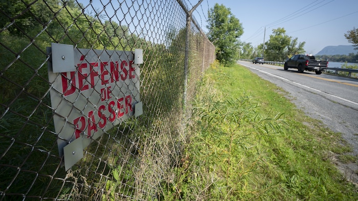 Une pancarte installée sur la clôture indique : « Défense de passer ».