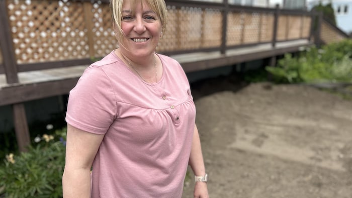 Annie Bérubé se tient devant sa résidence, la terre a récemment été retournée pour effectuer les tests dans le sol.
