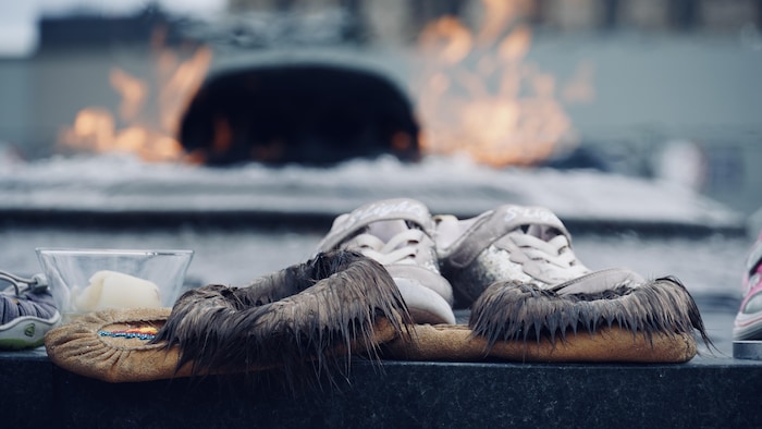 Une paire de mocassins devant la flamme du Centenaire.