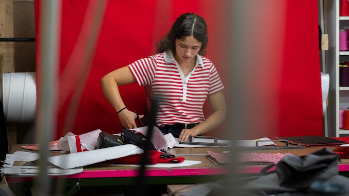 Aurélie découpe une pièce de tissu.
