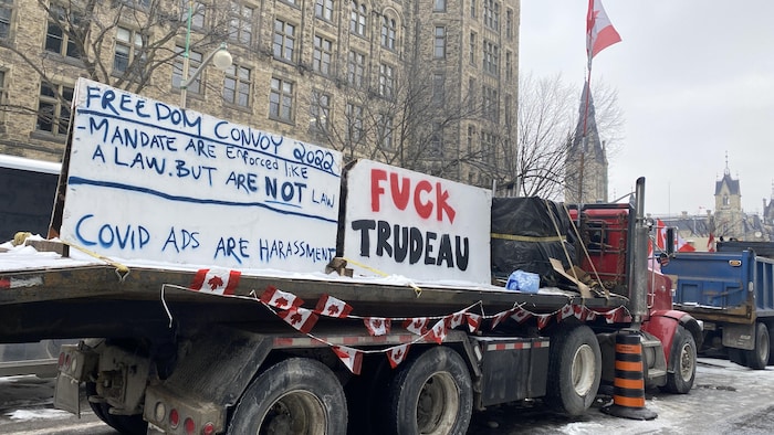 Un camion stationné le long d'un trottoir sur lequel il est écrit « Fuck Trudeau ».