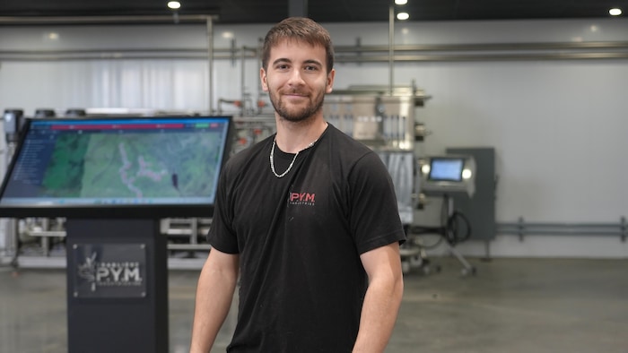 Portrait de Pierre-Yves Malenfant devant des équipements technologiques.