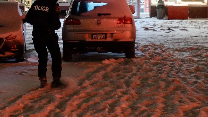 Un policier cherche dans la neige.