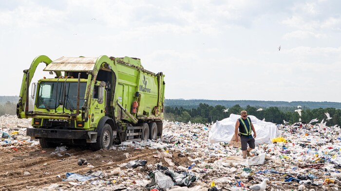 Un camion à déchets dépose sa cargaison. 
