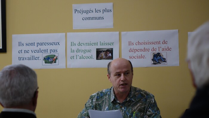 Un homme s'adresse à des gens.