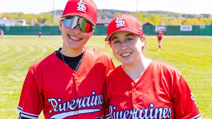 Deux personnes en tenue de baseball sur un terrain.
