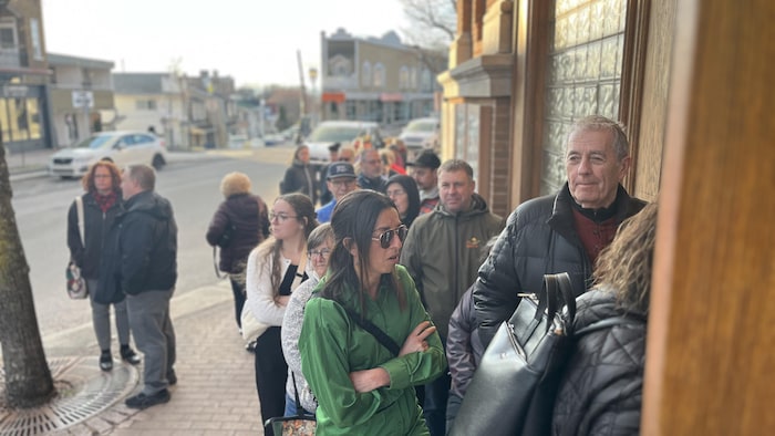 Une record de personnes attendant devant la porte d'un cinéma.