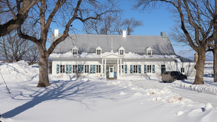 Un bâtiment blanc, dans un paysage enneigé.