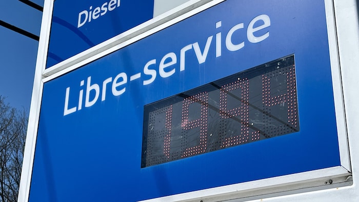 Le panneau lumineux d'une station-service affichant le prix de 199.4 le litre d'essence ordinaire.