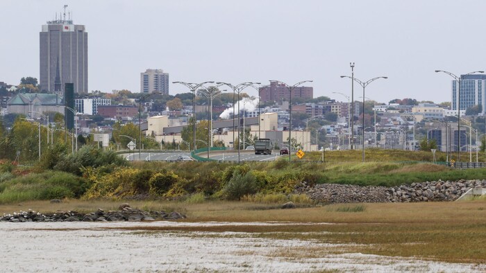 Une autoroute aménagée près d'une baie et une ville en arrière-plan.