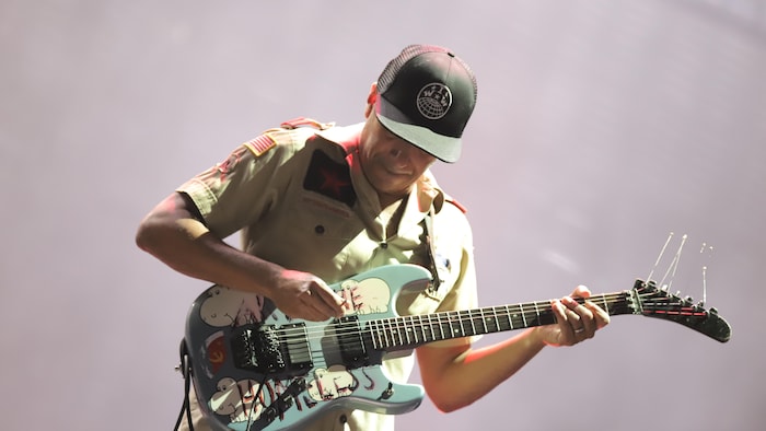 Le guitariste est penché sur son instrument.