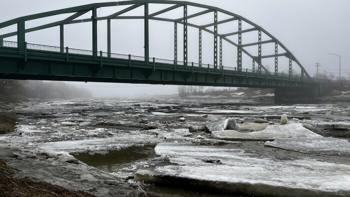 Le pont de Rivière-Ouelle et la rivière sur laquelle de grandes plaques de glace descendent.