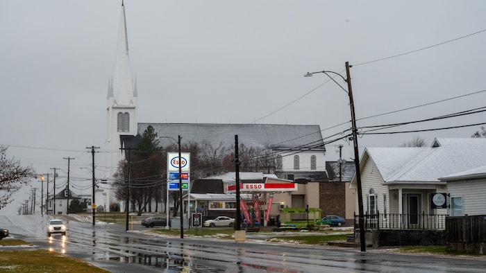 Une église et des maisons le long d'une rue.