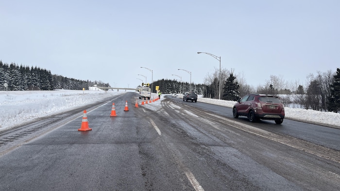Sortie d'autoroute fermée avec des cônes orange.