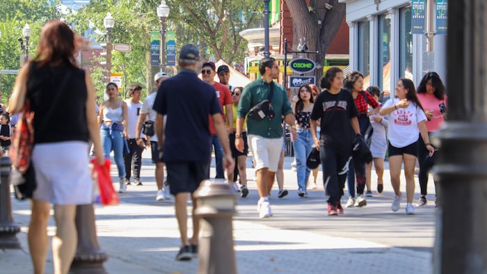 Des piétons circulent sur la rue Saint-Jean en été.