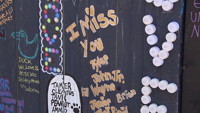 Une murale noire avec le message « Je m'ennuie de toi Tyler, John, Lil Wayne, Junior et Brian ».