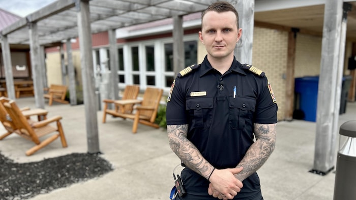 Un homme en uniforme de pompier se tient debout devant un centre communautaire.