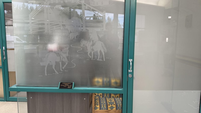Une porte vitrée avec des chevaux gravés dessus.