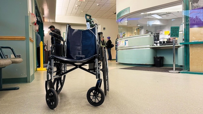 Une chaise d'hôpital vide au milieu d'un couloir.